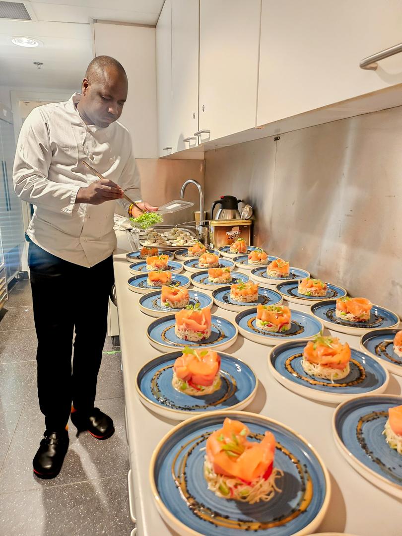Chef plating salmon dishes for a large event
