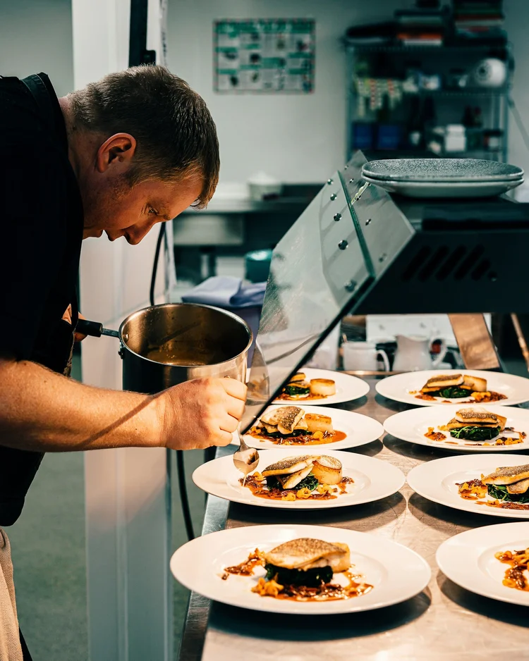 Chef plating food in a professional kitchen